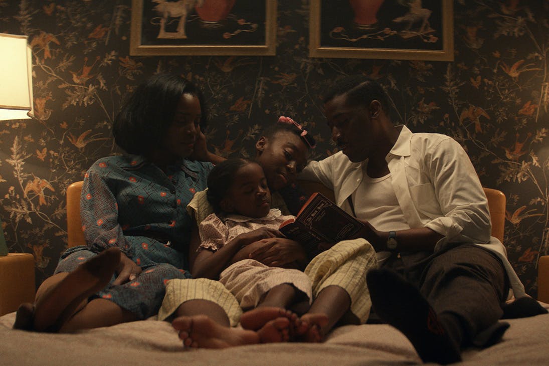 a family cuddles up close on a couch.